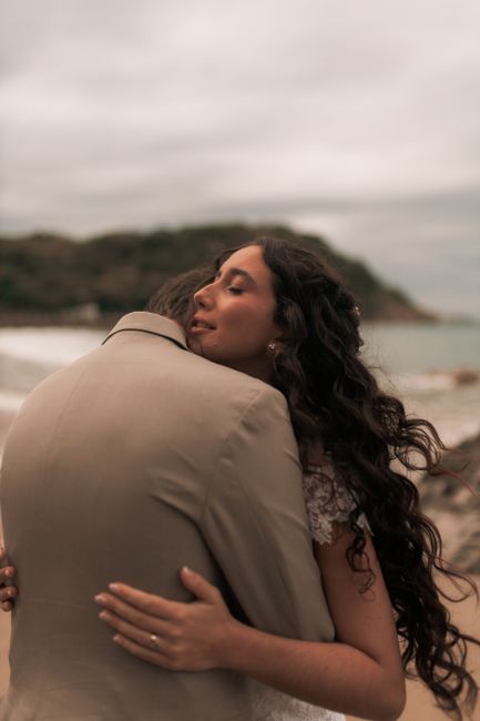 A couple warmly embraces on a serene beach during sunset, exuding love and tranquility.