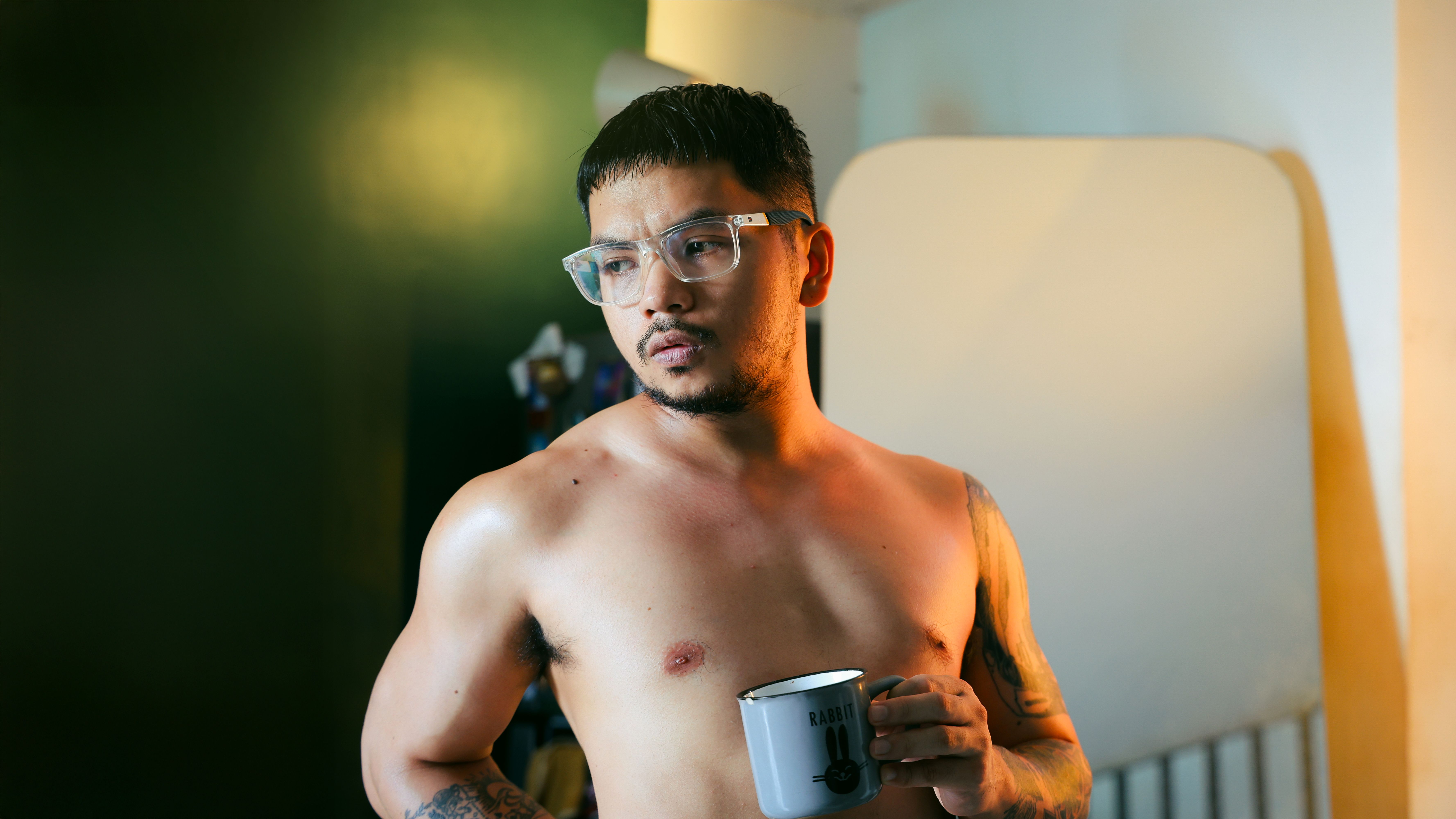Contemplative man holding a coffee mug indoors in soft light