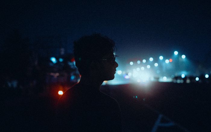 Silhouette of a person against city streetlights at night, creating a moody urban atmosphe, by Aritra Hazra on Pexels
