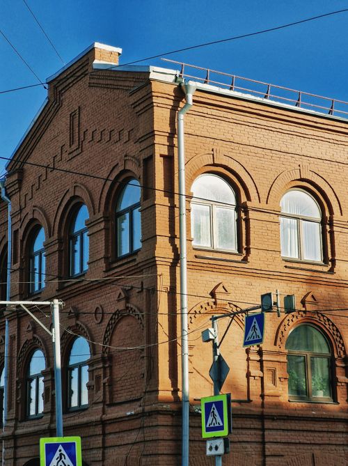 Free Architectural photo of a historic brick building in a city with clear blue sky. Stock Photo