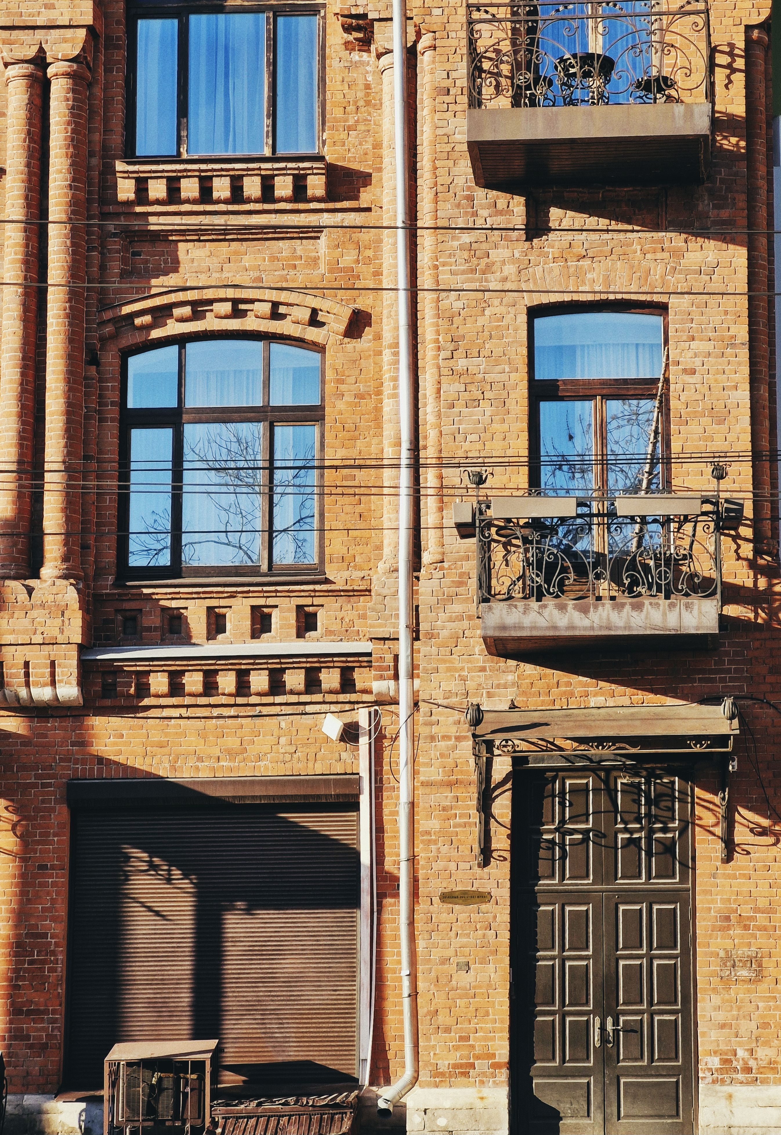 Vintage Red Brick Building Facade with Balconies · Free Stock Photo