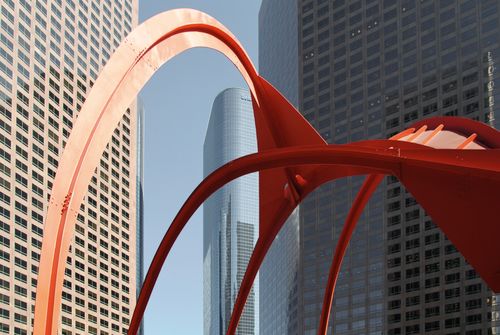 Free A striking red sculpture contrasts with urban skyscrapers in a bustling cityscape. Stock Photo