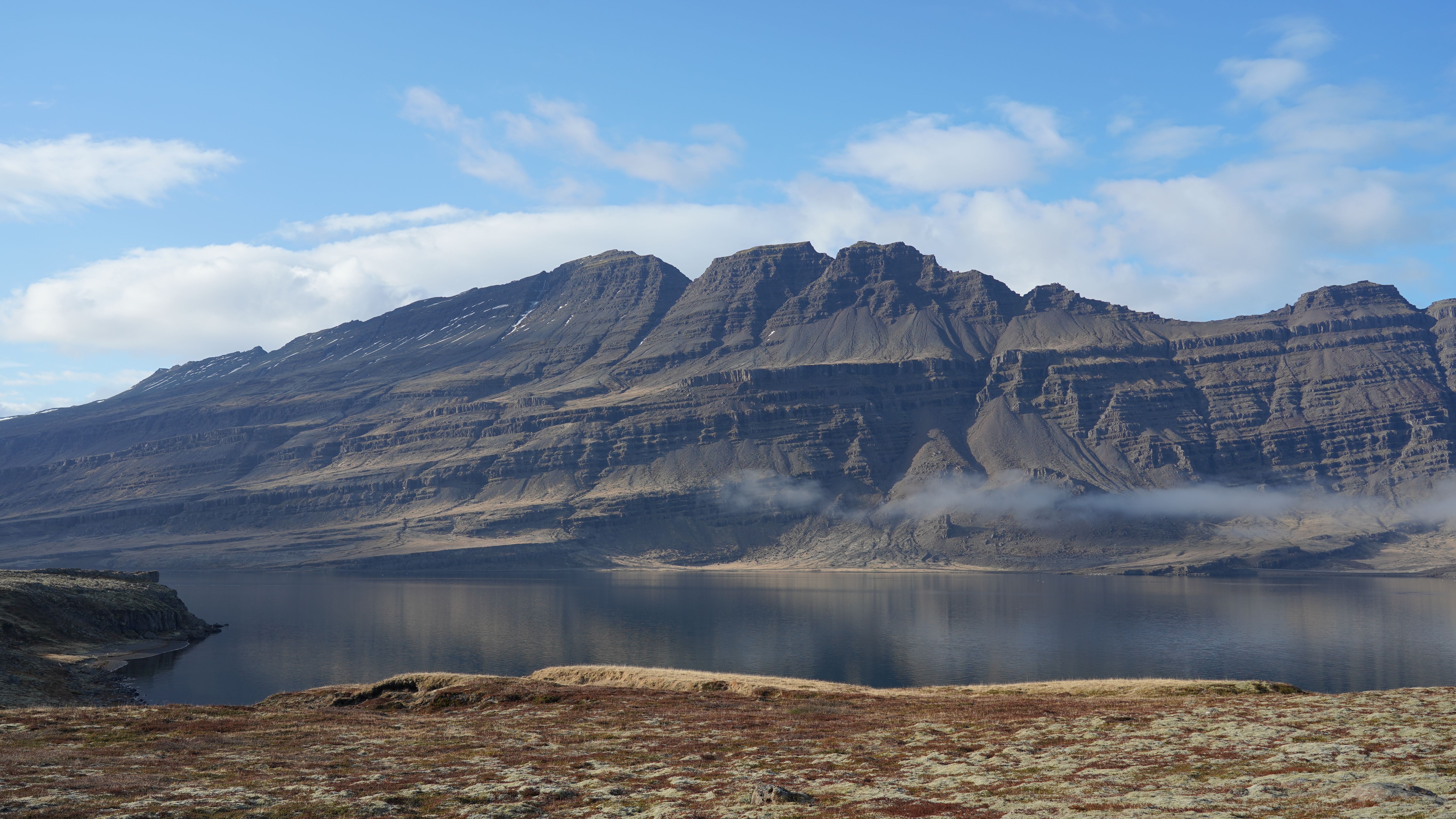 Stunning view of Icelandic mountain with clear blue sky and serene lake