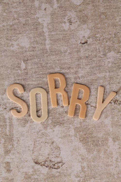 Free Letters spelling 'sorry' arranged on a rustic surface, conveying an apology theme. Stock Photo