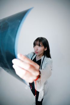 A female doctor analyzing an X-ray in a clinical setting, offering medical expertise.