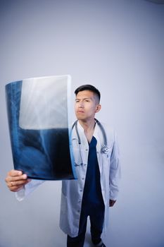 A doctor carefully examines a chest X-ray, showcasing medical expertise and focus.