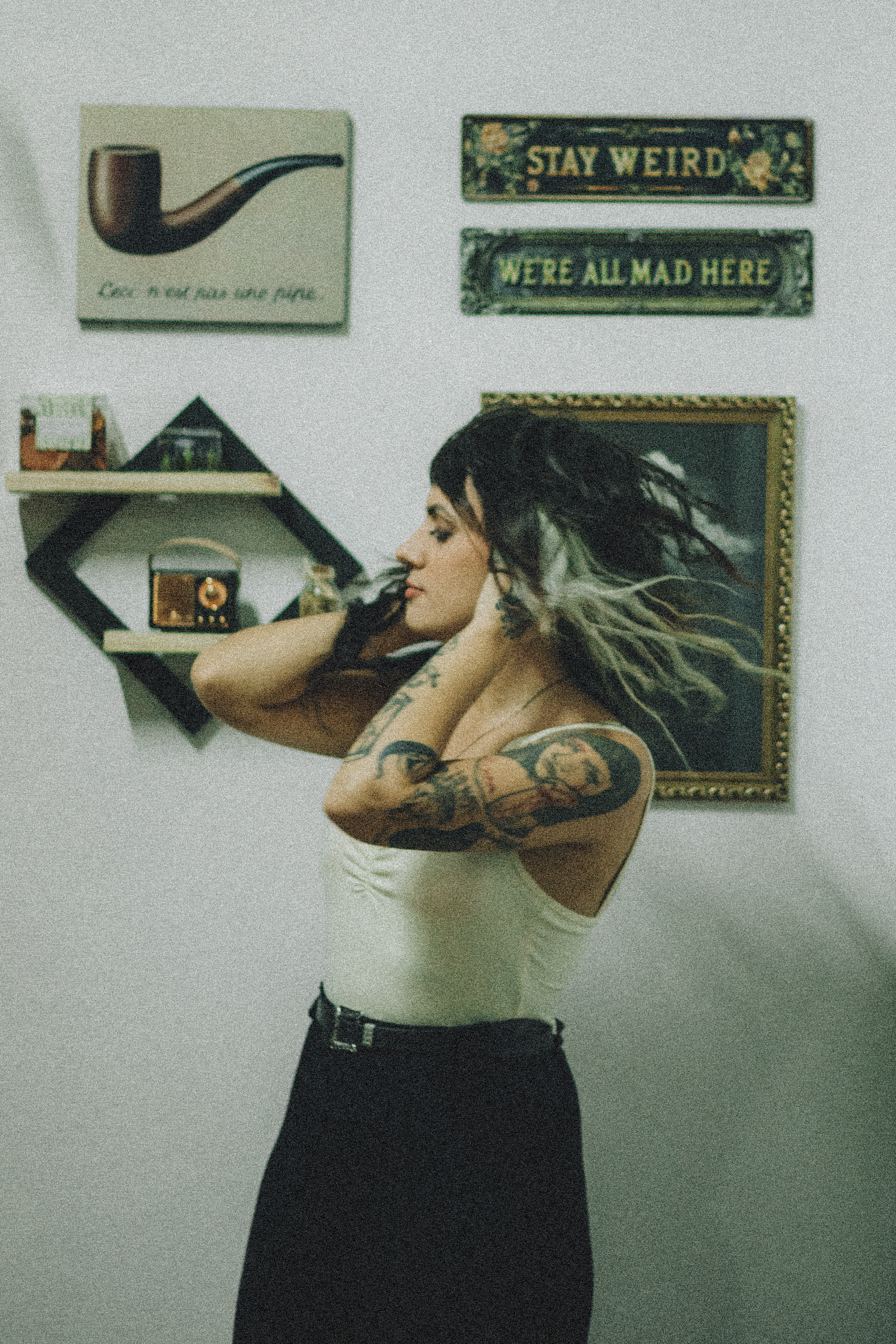 Woman with tattoos in a stylish living room, exuding an artistic vibe.