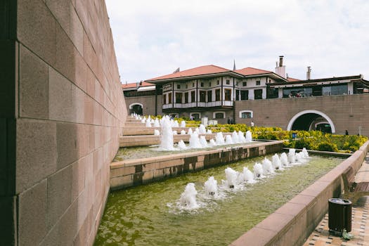 A vibrant fountain plaza near historic buildings in Ankara, Türkiye, showcasing architecture and lively water features.