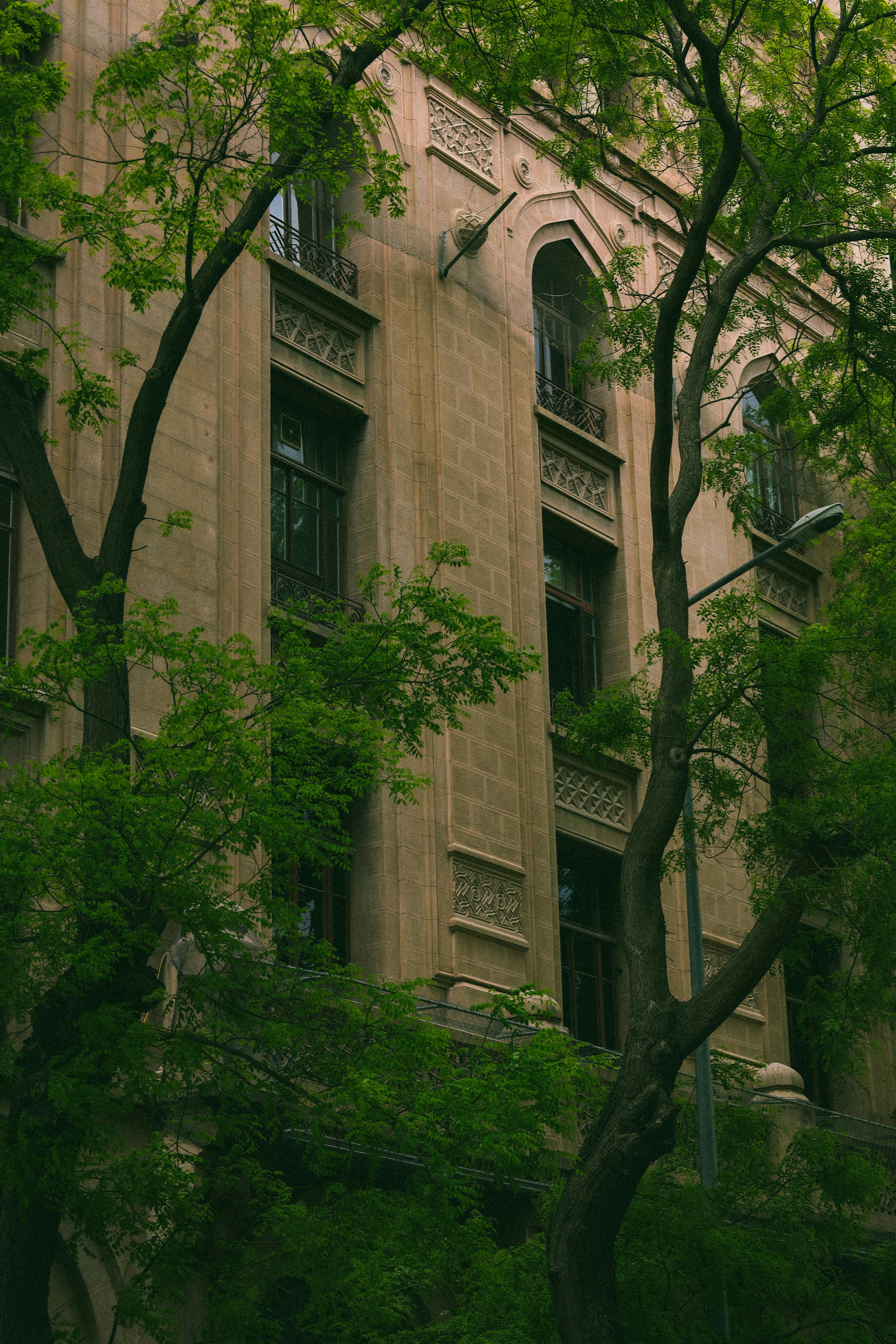 A historic building facade in Ankara, Türkiye surrounded by vibrant green trees.