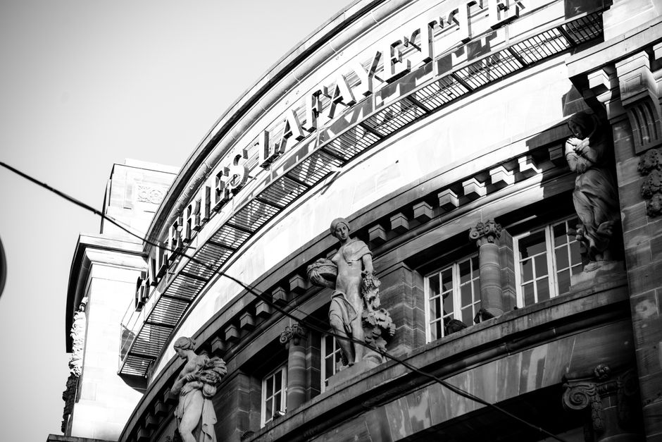 Dramatic black and white photograph of the iconic Galeries Lafayette facade in Strasbourg, France.