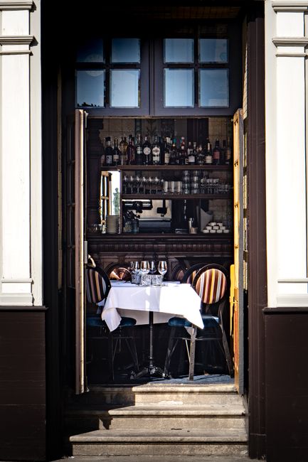 Inviting entrance to a charming bistro in Nantes with an elegant table setting.