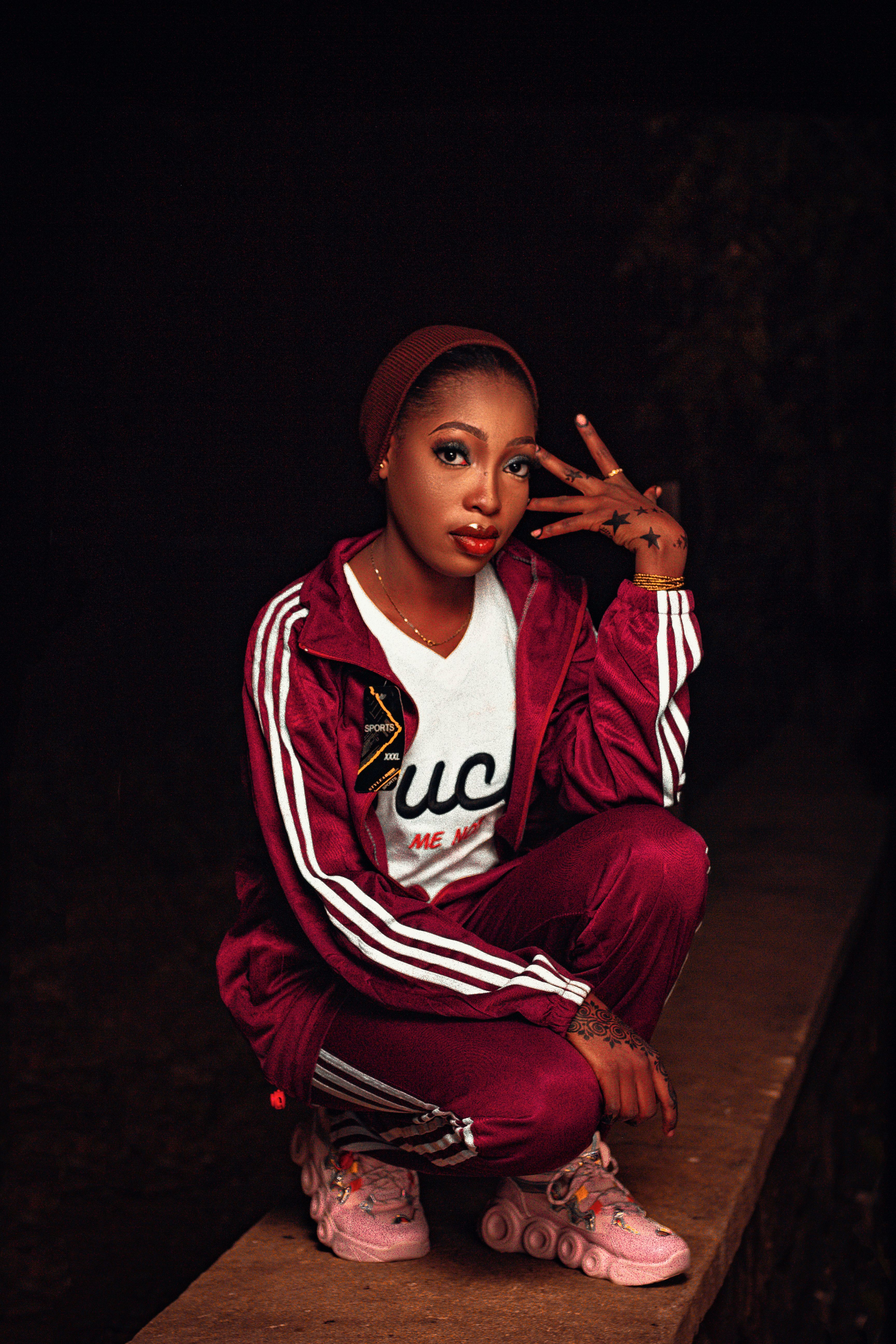 Young woman posing in a stylish tracksuit at night with a confident expression.