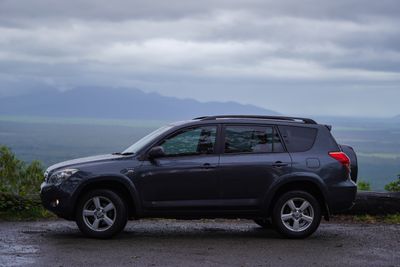 Charcoal crossover parked on a ridge above a valley, photo by Paul Pulimoottil on Pexels