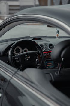 Detailed view of the interior of a luxury sports car, showcasing the steering wheel and dashboard.