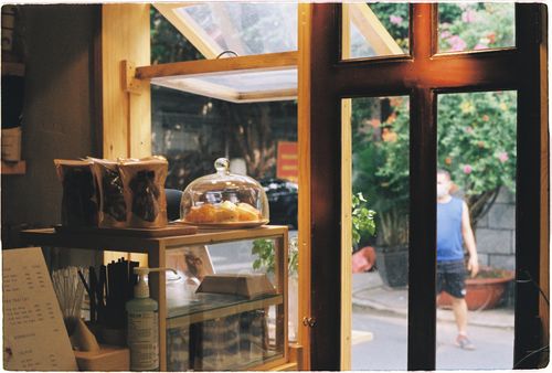 Free Warm cafe interior with pastries and an open window overlooking a garden. Stock Photo