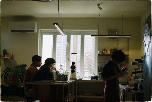 Free A cozy coffee shop interior with customers and a barista working behind the counter. Stock Photo