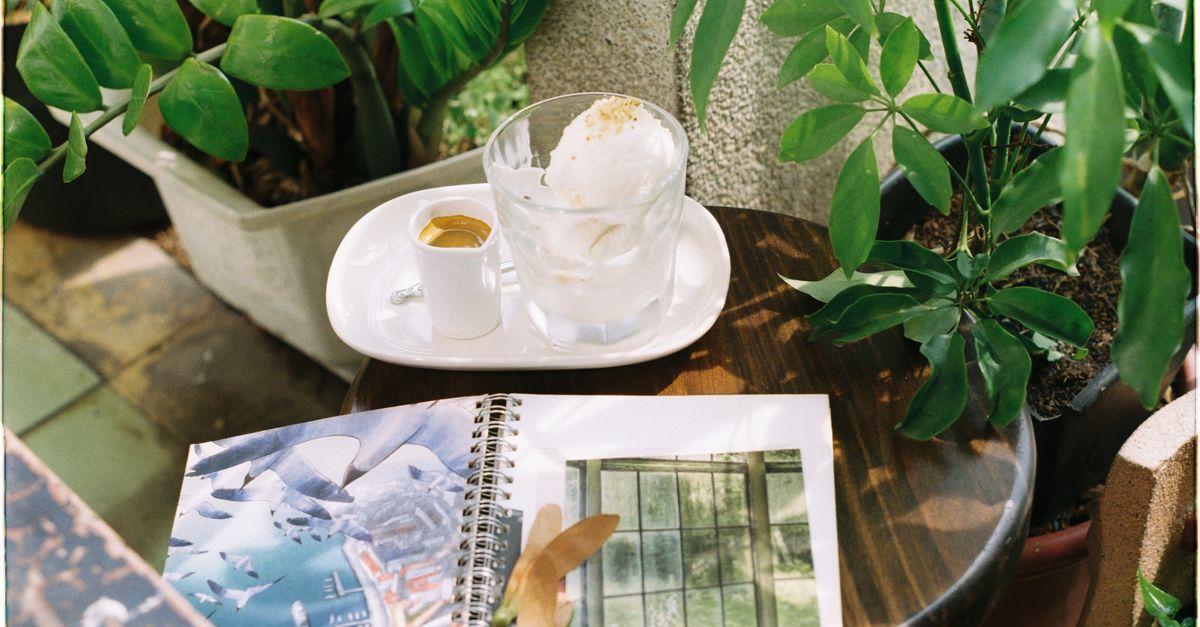 cozy cafe terrace in a small European village with a coffee and notebook on the table