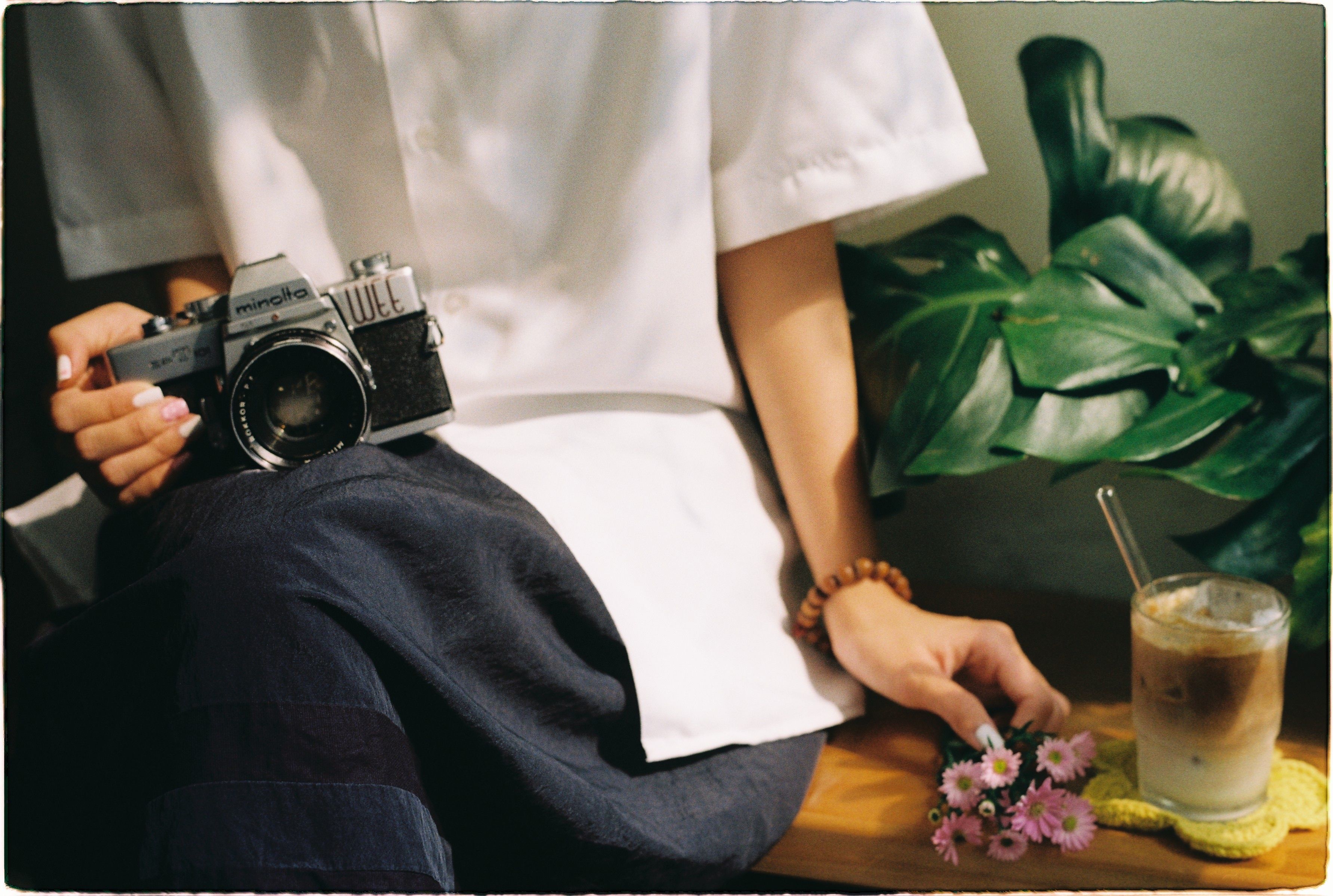 Relaxed scene with a vintage camera, coffee, and flowers.