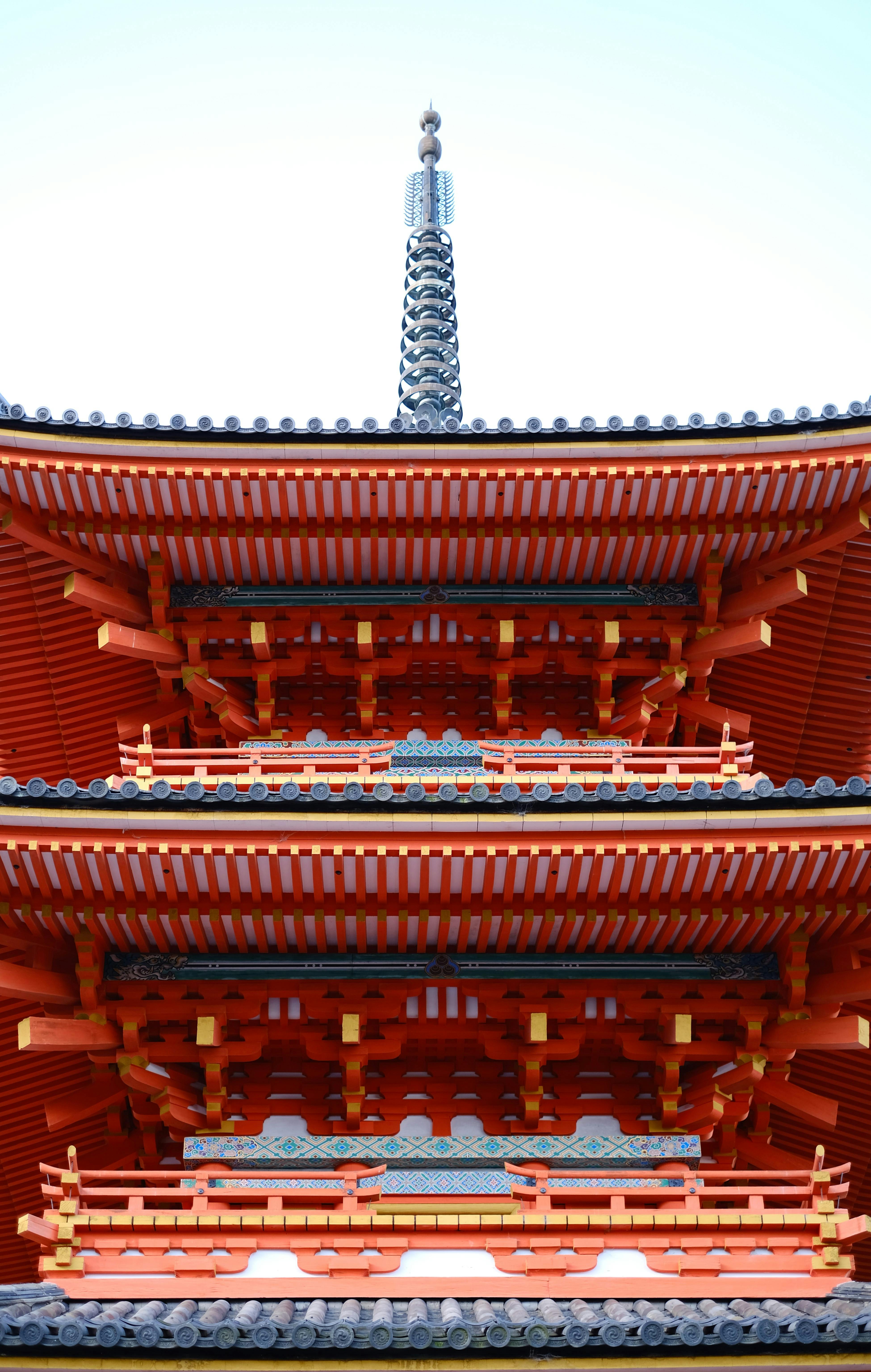 Close-up of a vibrant red Japanese pagoda showcasing traditional architectural details.