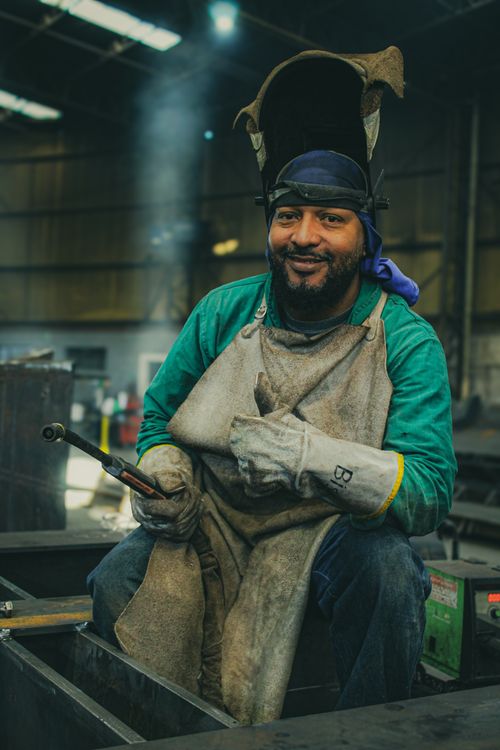 Free A skilled welder poses confidently in a busy industrial workshop, exuding expertise and craftsmanship. Stock Photo