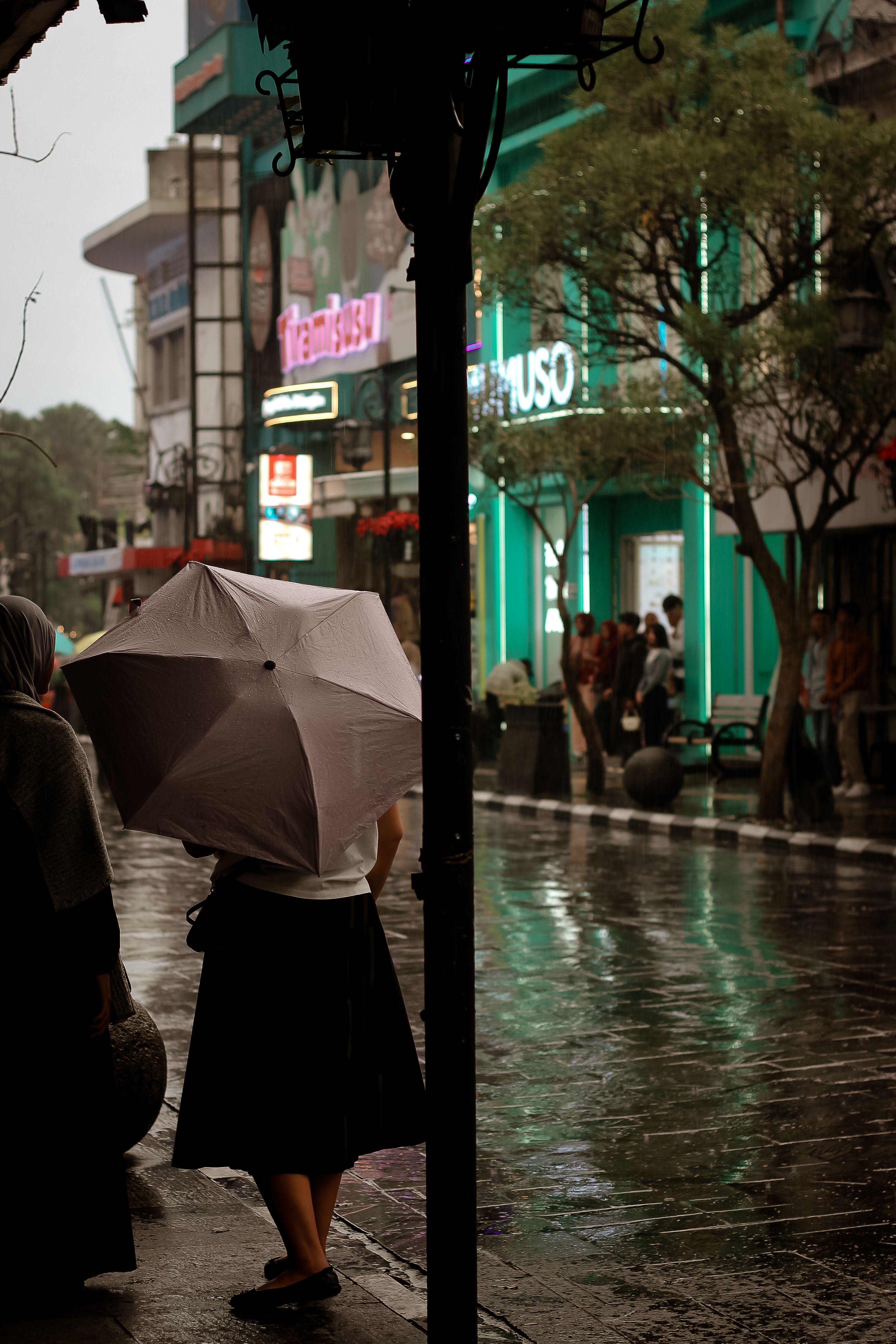 Scène de rue sous la pluie en Indonésie avec parapluies