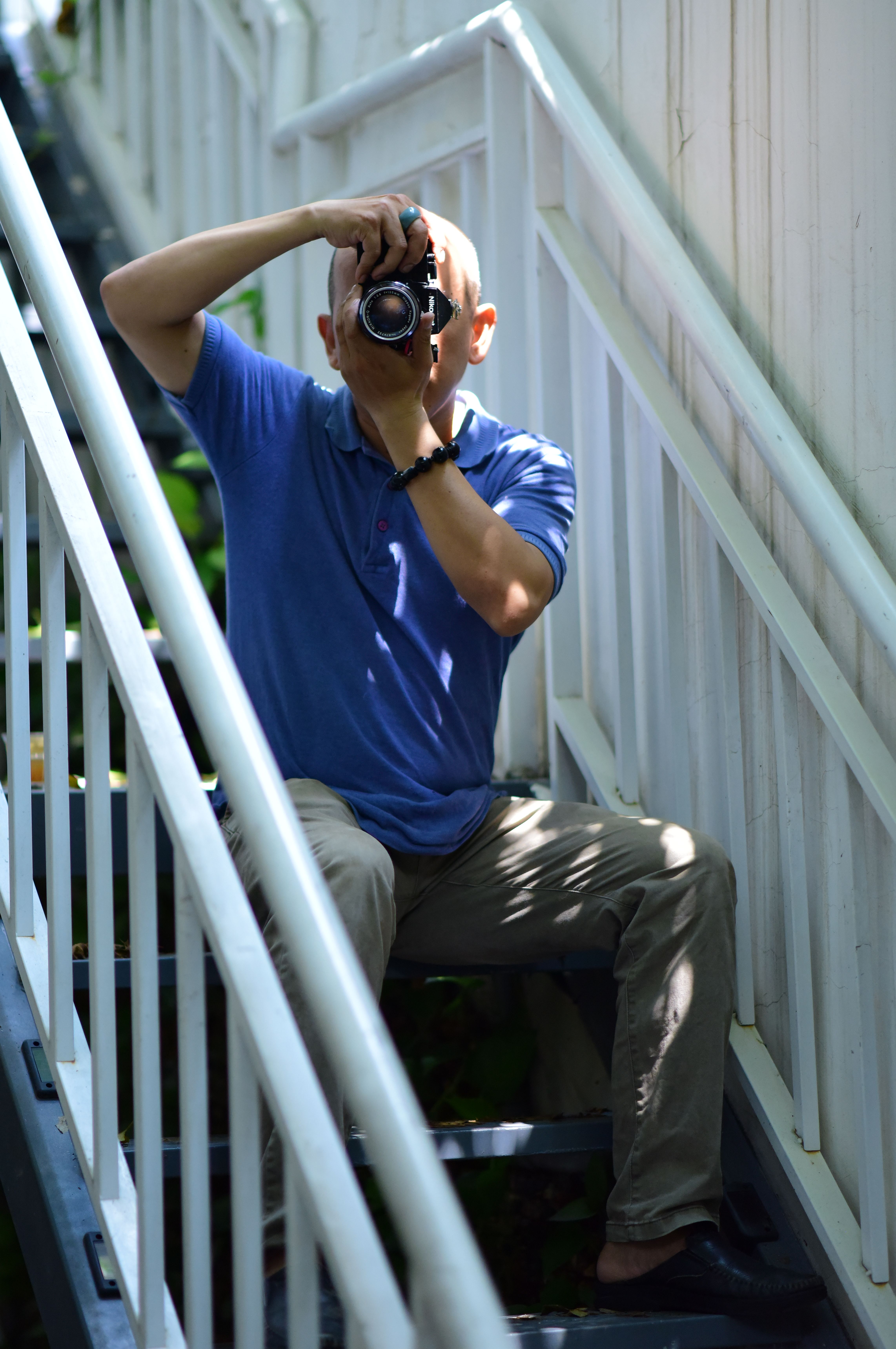 Photographer sitting on outdoor staircase, capturing a perfect shot.