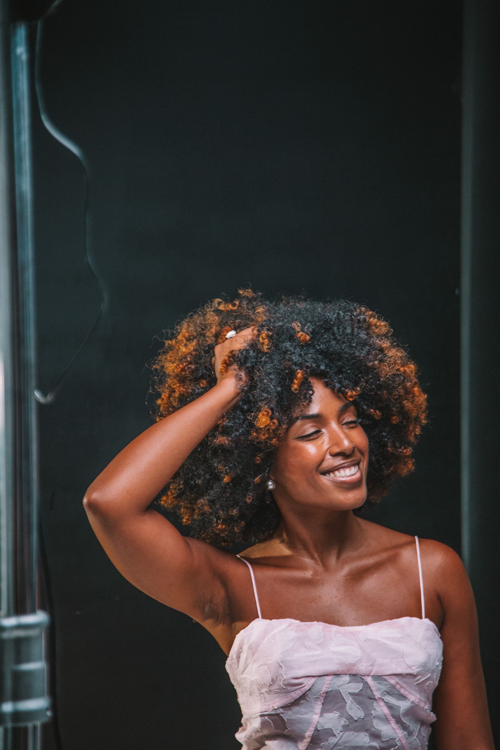 Smiling person with natural curly hair