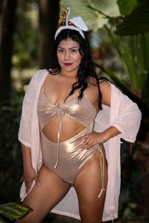 Free Confident woman in a shimmering bikini with robe and unicorn headband, posing outdoors. Stock Photo