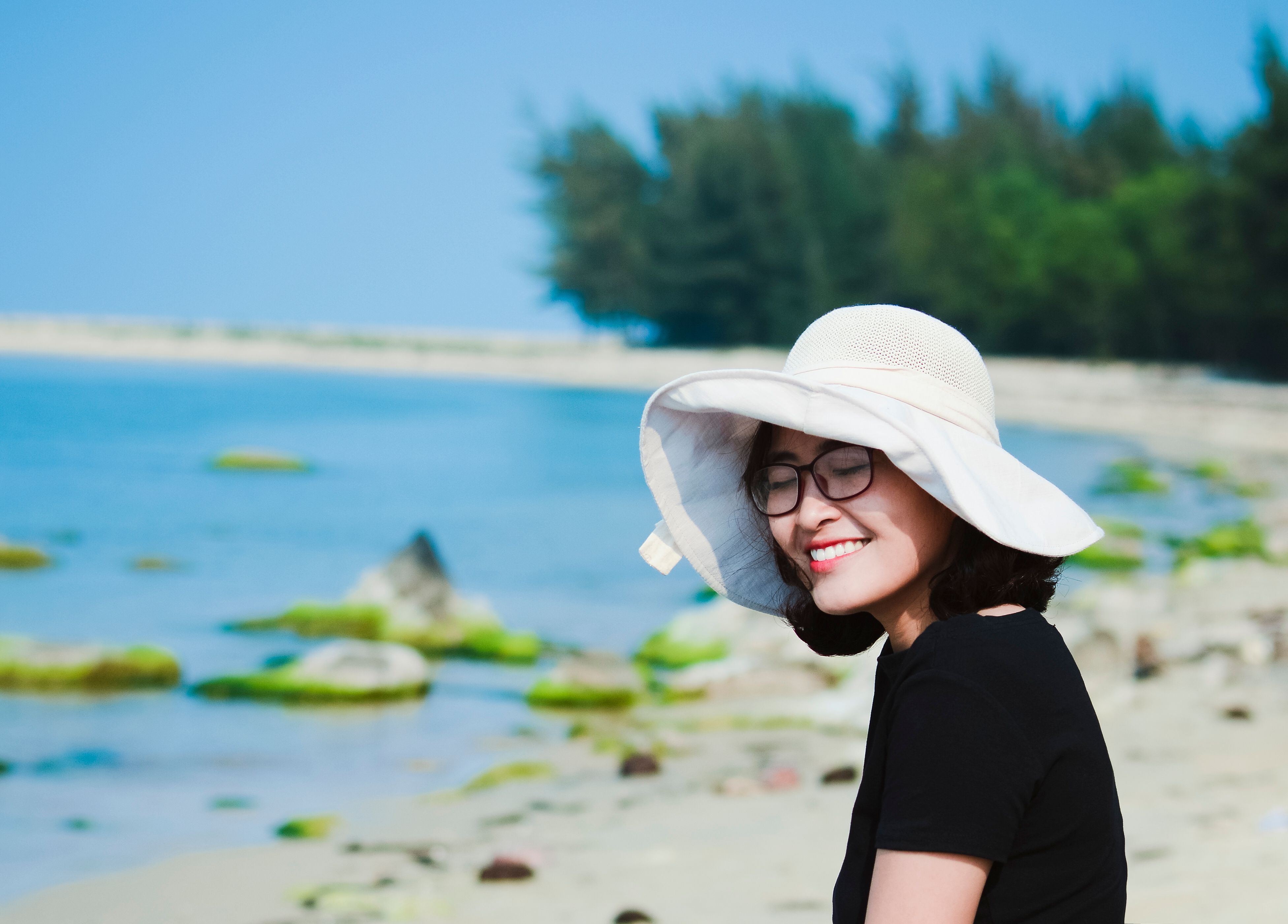 Woman Smiling in Sun Hat by the Beach · Free Stock Photo