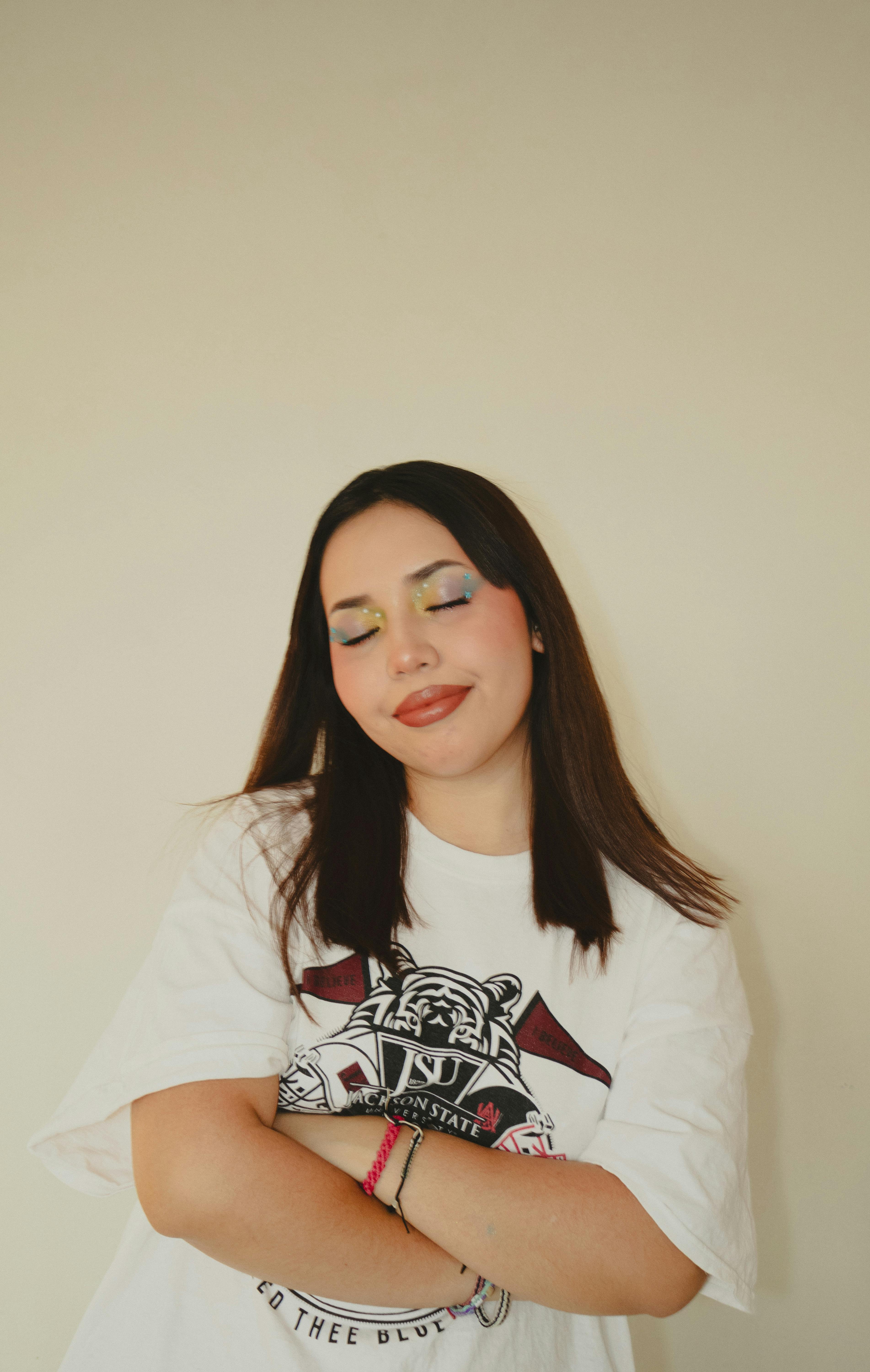 De franc Retrat d'una dona jove amb ombres d'ulls de colors, somrient amb els ulls tancats, vestida de manera informal. Foto d'estoc