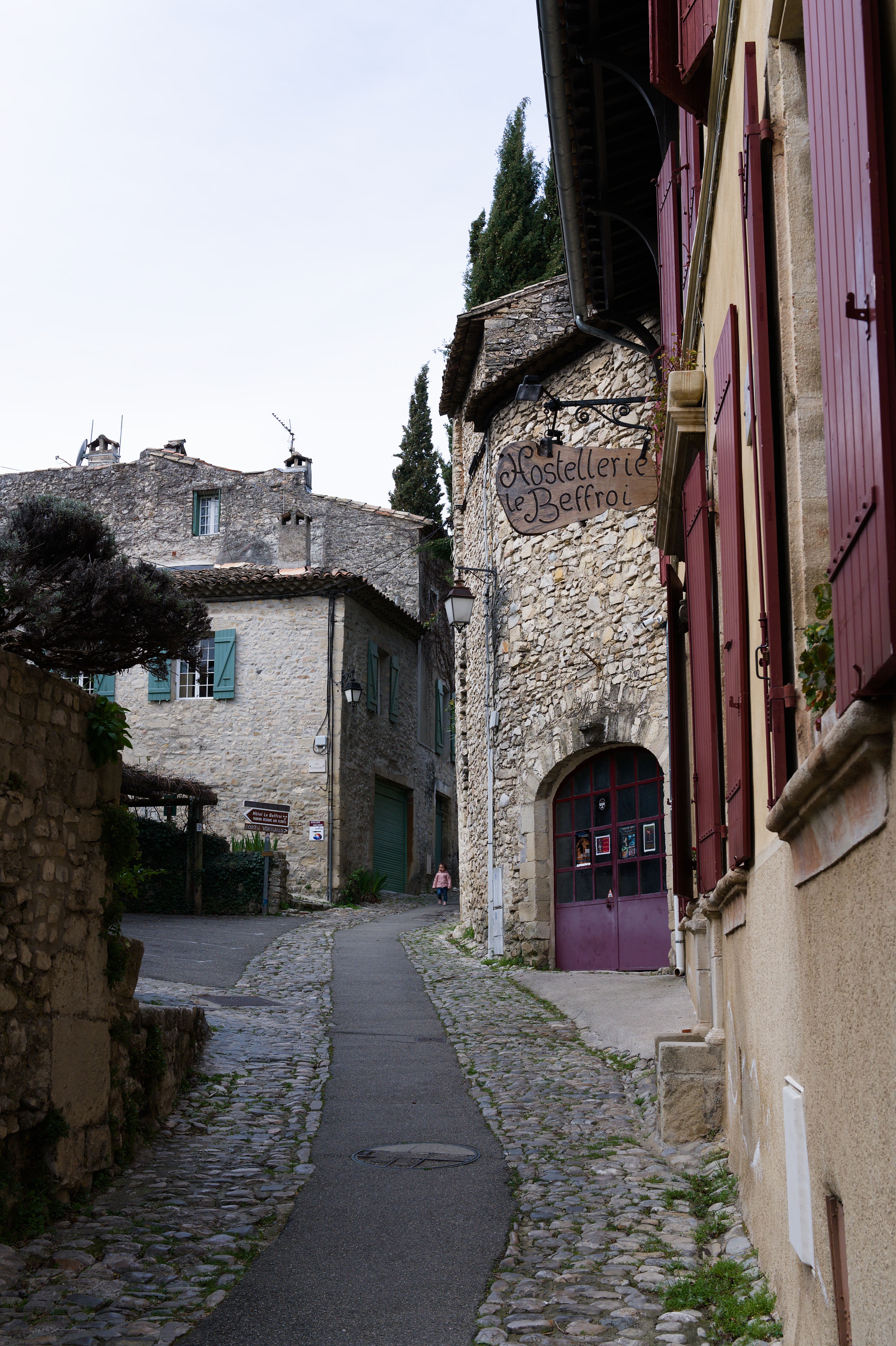 A picturesque cobblestone street lined with stone houses in Vaison-La-Romaine, France.
