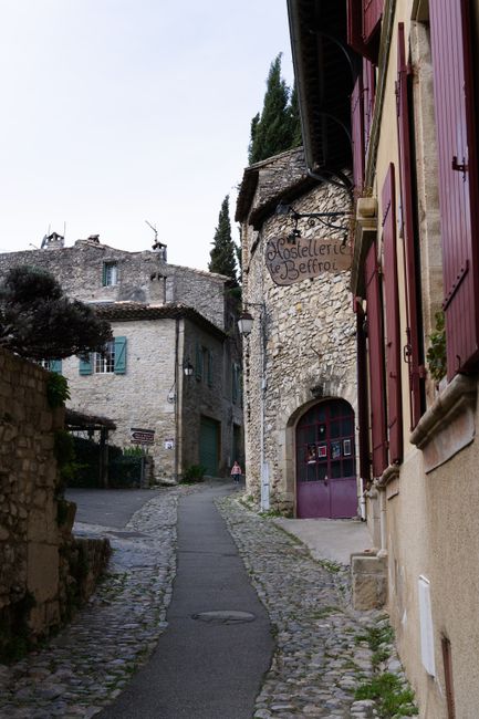 A picturesque cobblestone street lined with stone houses in Vaison-La-Romaine, France.