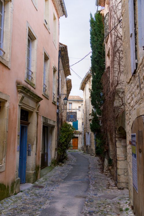 Free Narrow cobblestone street in Vaison-La-Romaine, France, with historic buildings and rustic charm. Stock Photo
