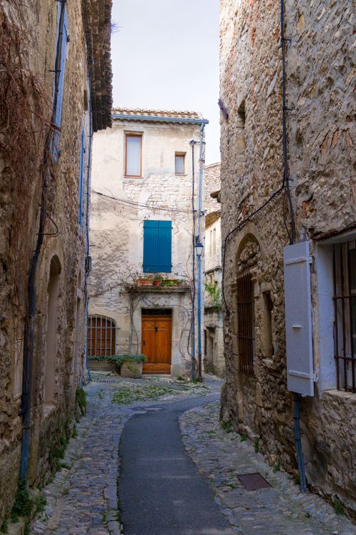 Free Quaint cobblestone street lined with rustic stone buildings in Vaison-la-Romaine, France. Stock Photo