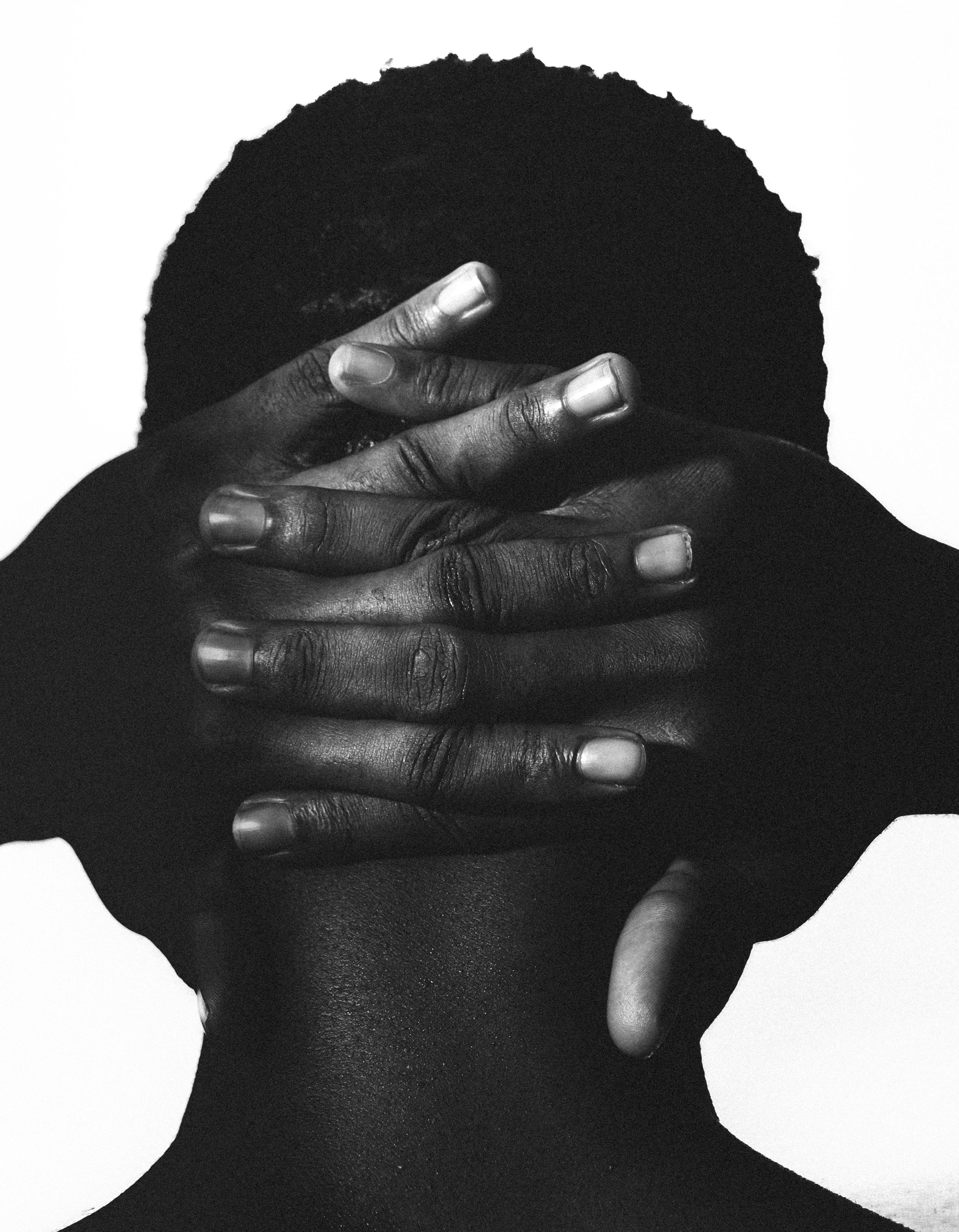 Minimalist black and white portrait with hands behind head, artistic composition.