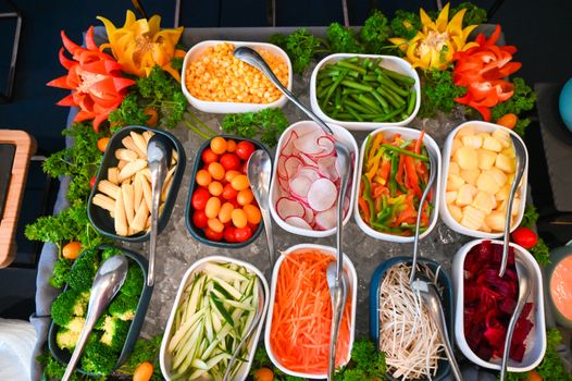 An overhead view of a vibrant salad bar with fresh vegetables and garnishes.