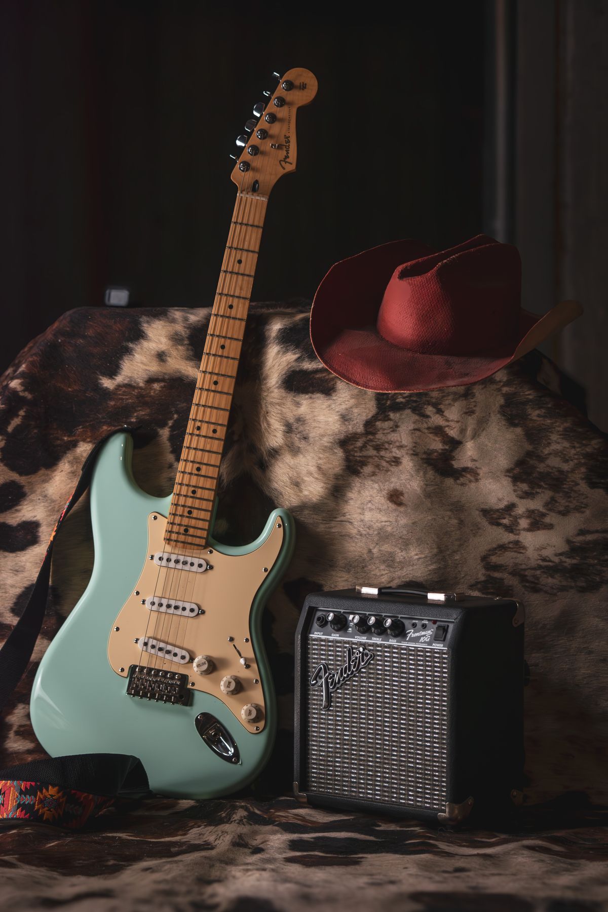 Mint green electric guitar beside an amp