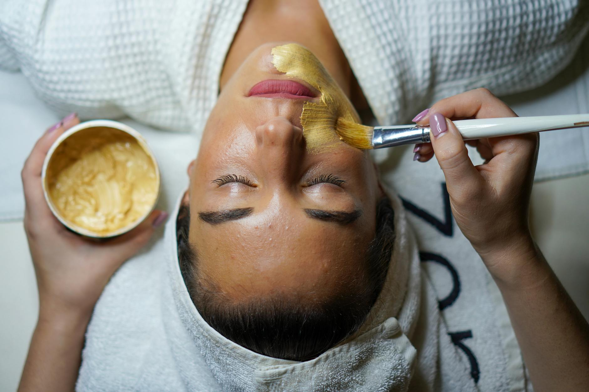 Woman smiling while sitting on her couch with her budget spread out on the table.