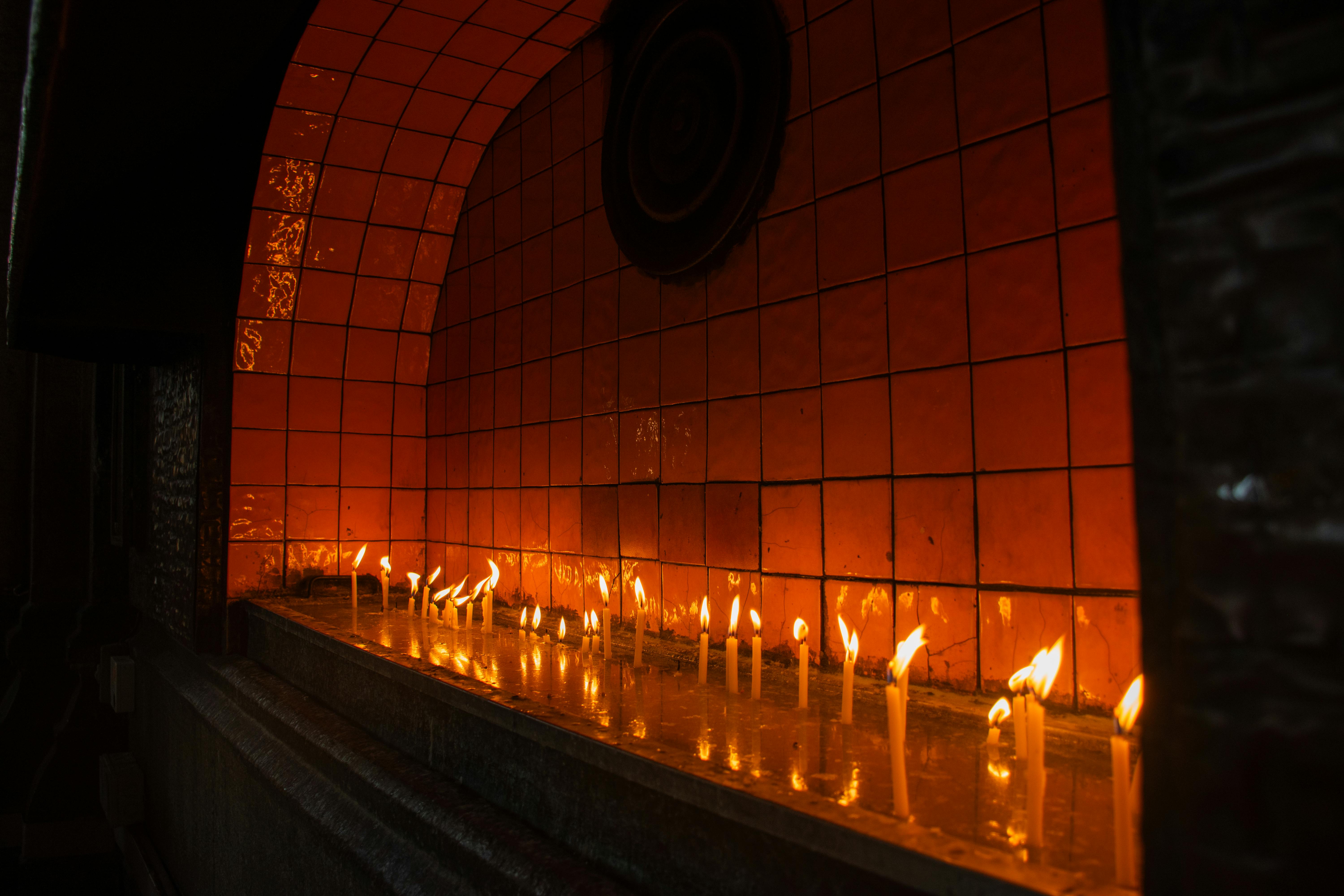 Serene image of candles burning in an indoor altar setting with a warm glow.
