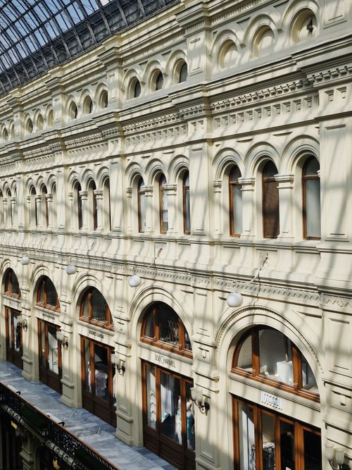 Free Elegant historic shopping arcade interior with arched windows and intricate detailing under a glass roof. Stock Photo