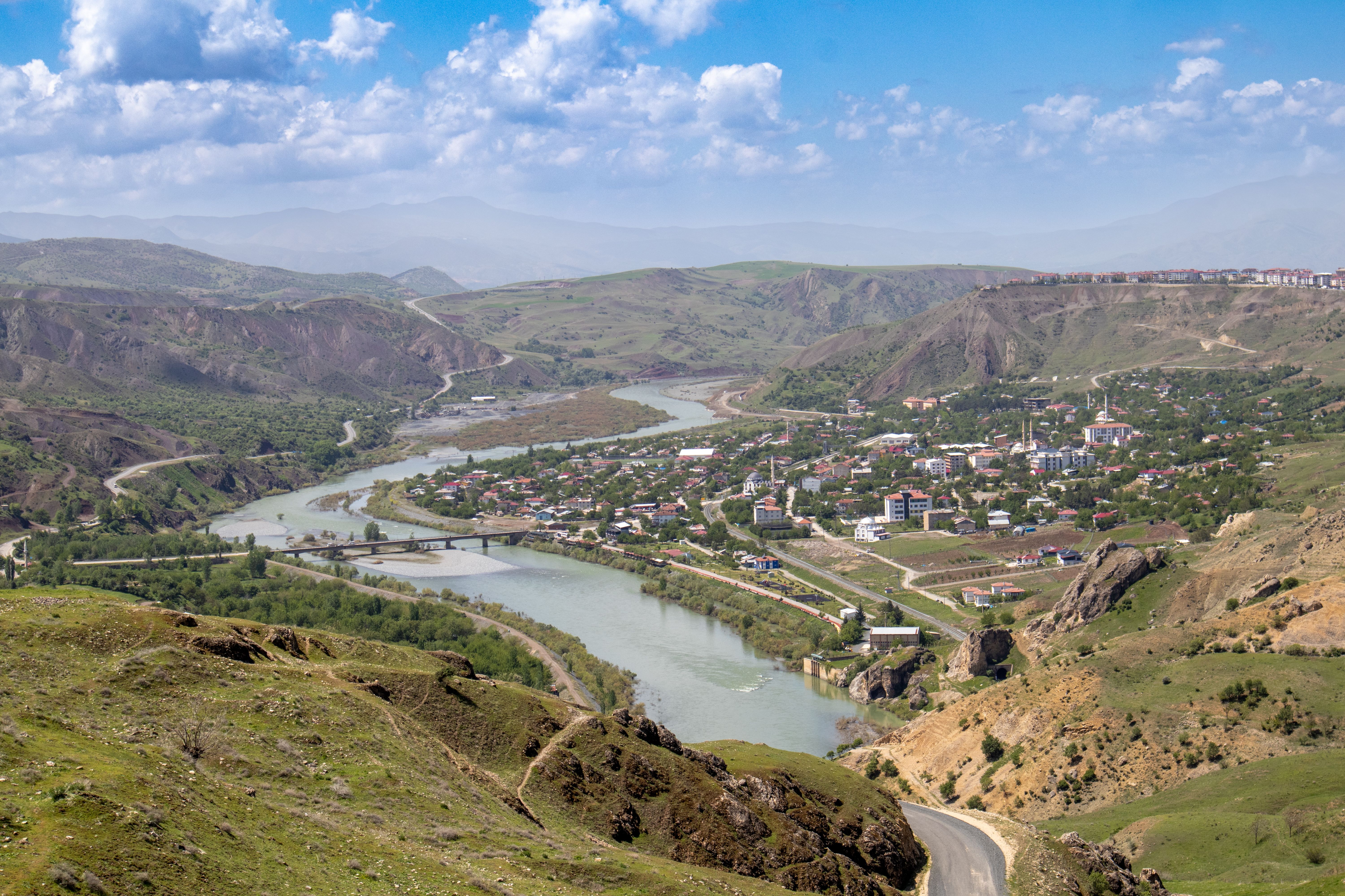 Aerial view of Palu, Elazığ, Türkiye, featuring the winding Euphrates River and surrounding hills.