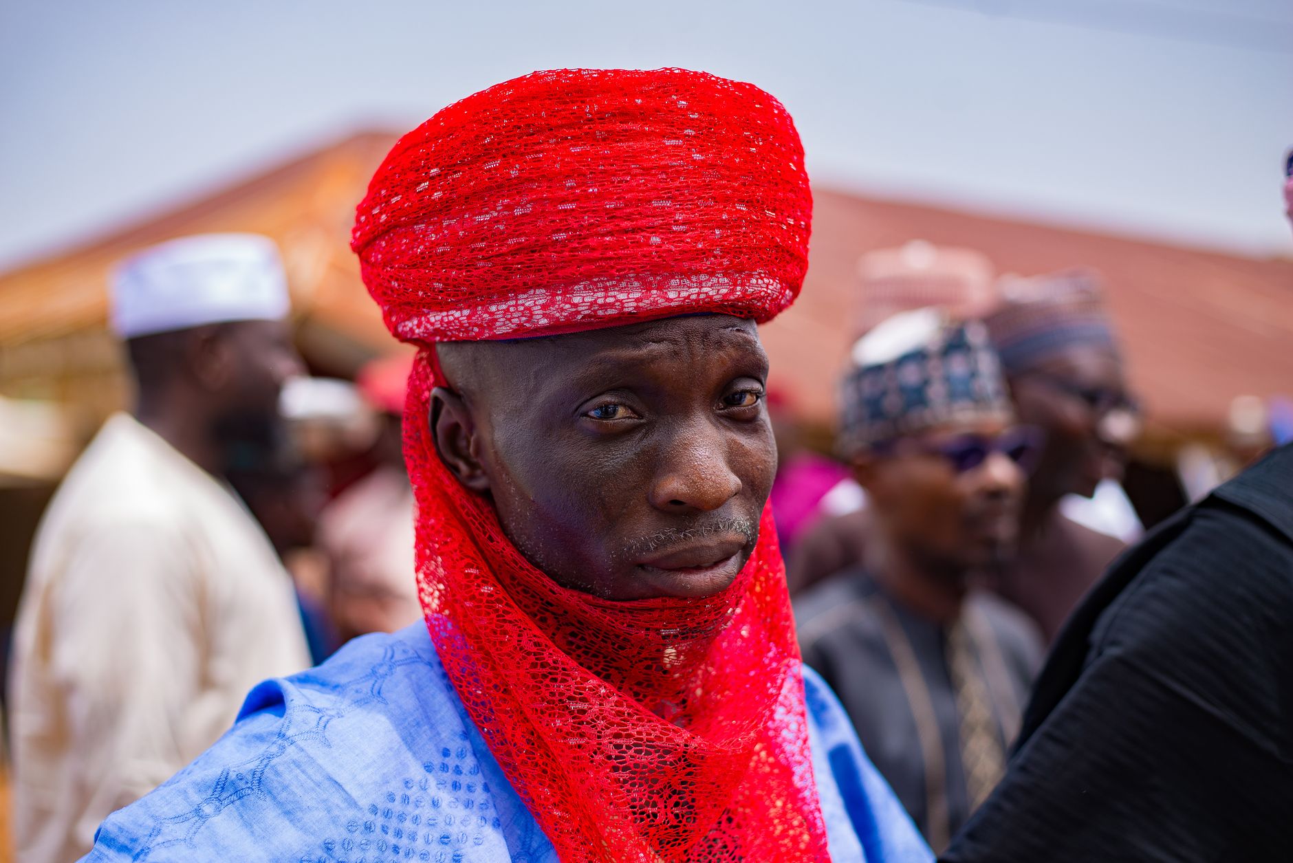 A man wearing traditional Nigerian attire with vibrant colors and elegant patterns.