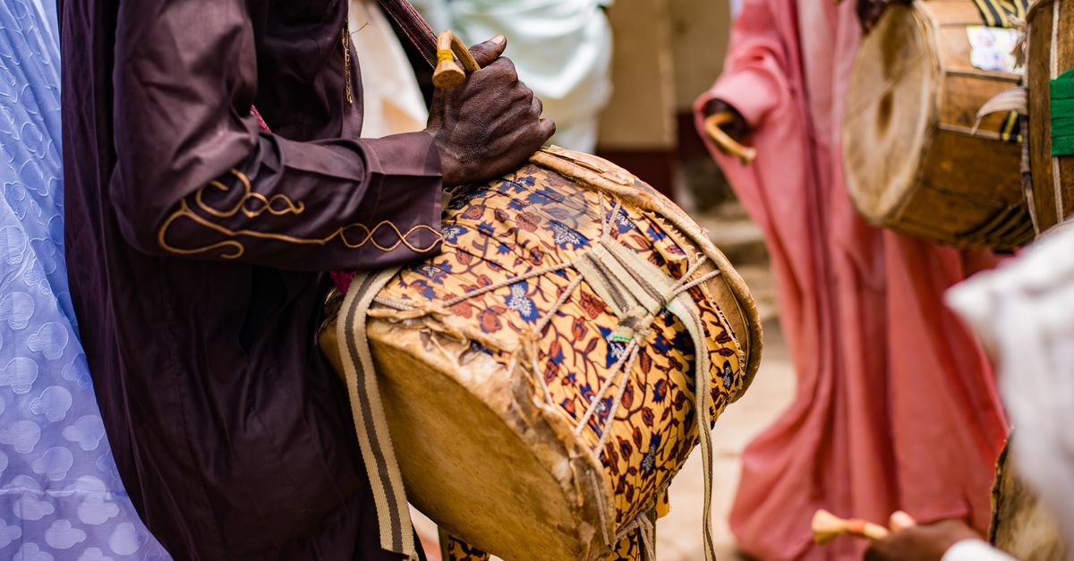 Musicians playing traditional Ewe drums and modern instruments in a church setting in Ho