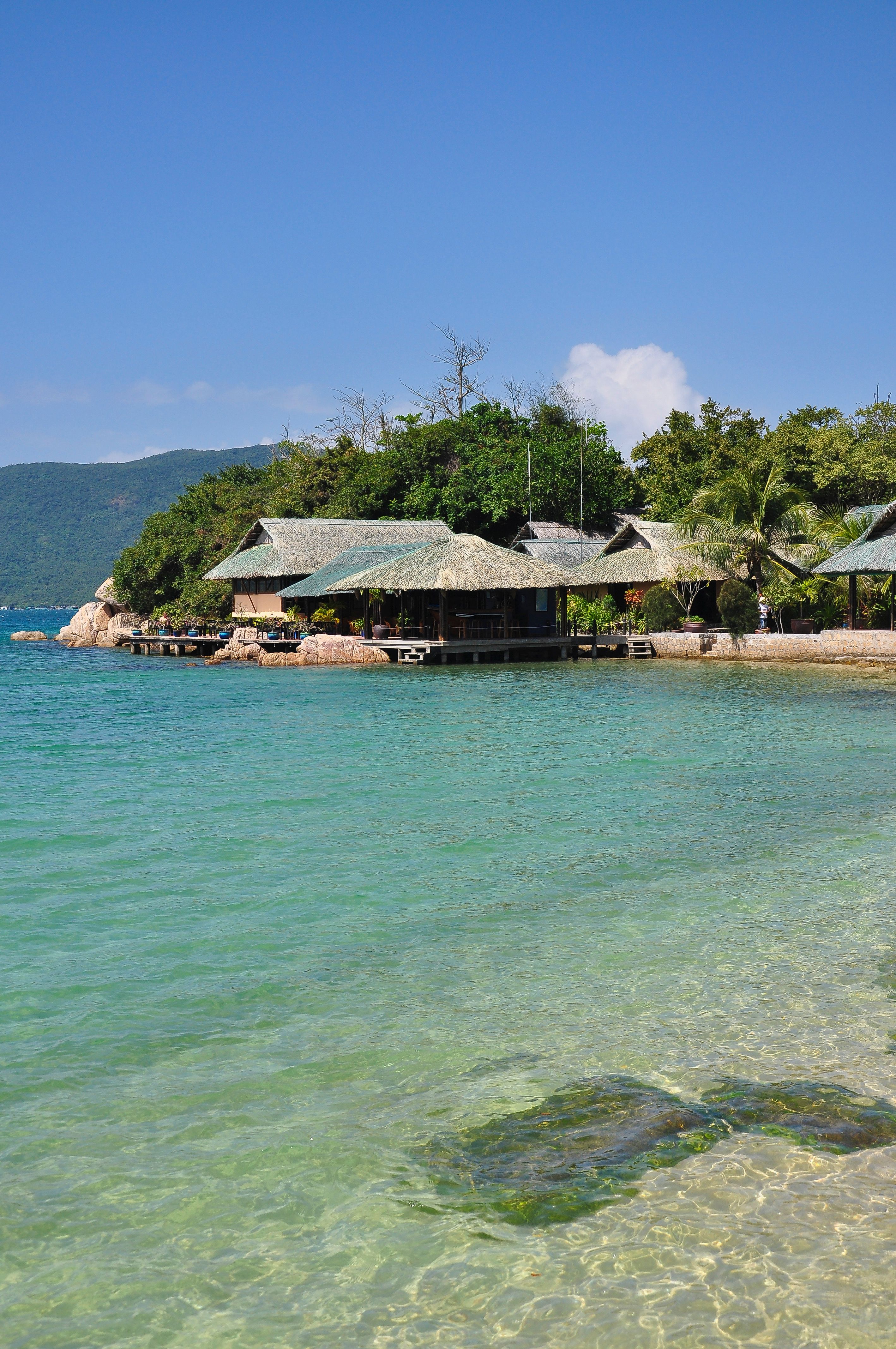 Scenic view of crystal-clear waters and lush greenery in Khánh Hòa, Vietnam.