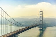 从空中俯瞰，薄雾环绕着旧金山标志性的金门大桥，尽显其宏伟