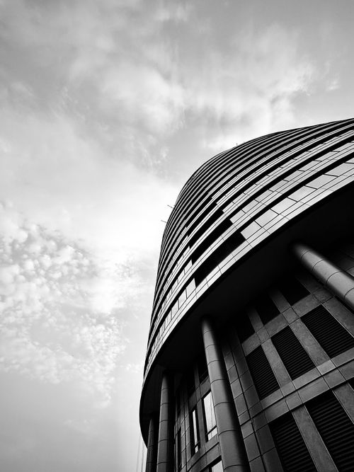 Free Dramatic perspective of a modern building against a cloudy sky, emphasizing architectural innovation. Stock Photo