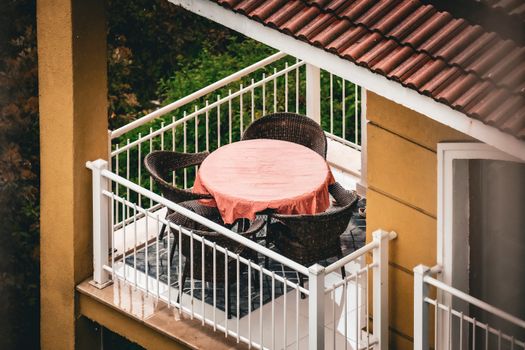 Cozy balcony view with table and chairs during rain in İstanbul, Türkiye.