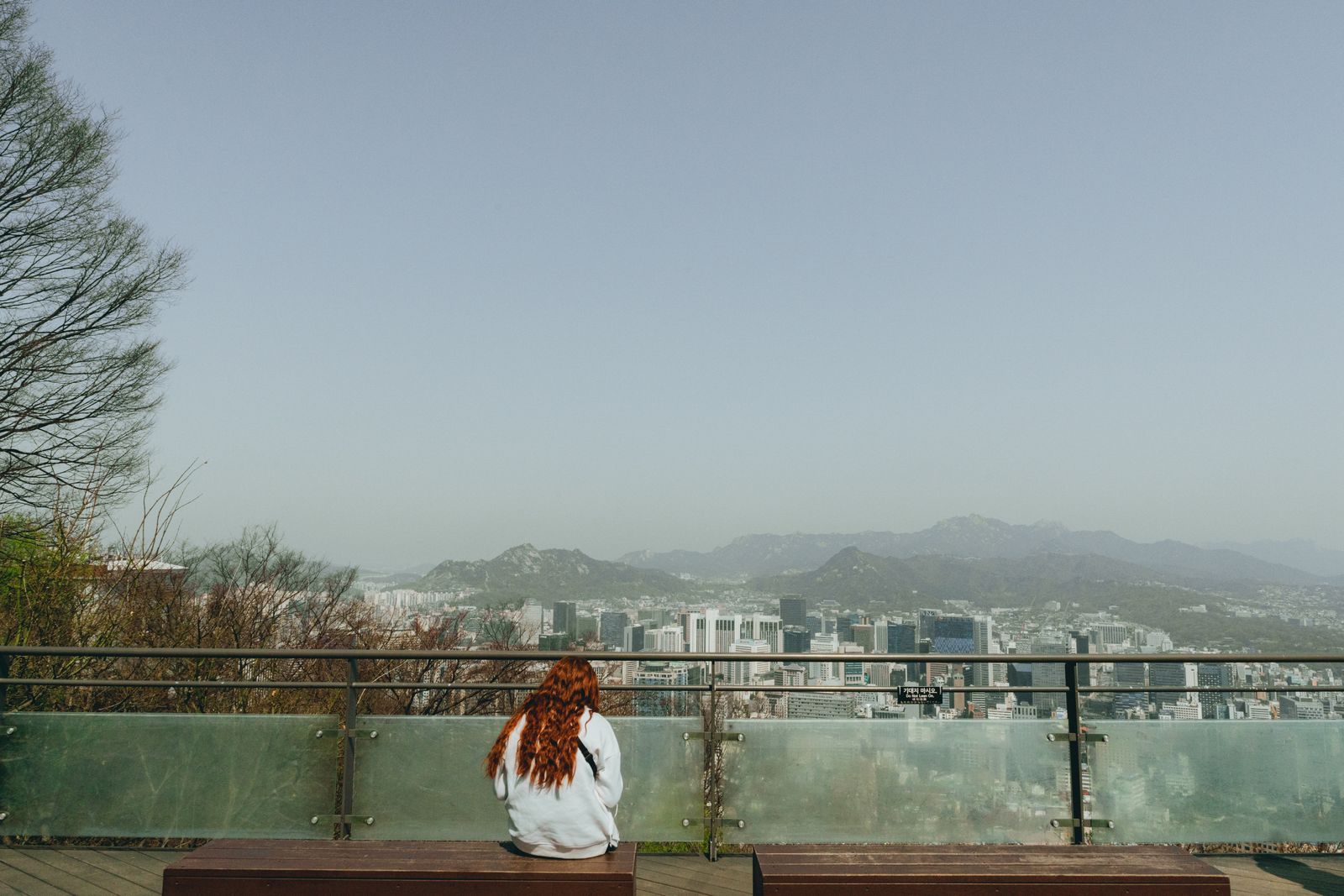 A visitor enjoying the view across Seoul from a Namsan viewpoint