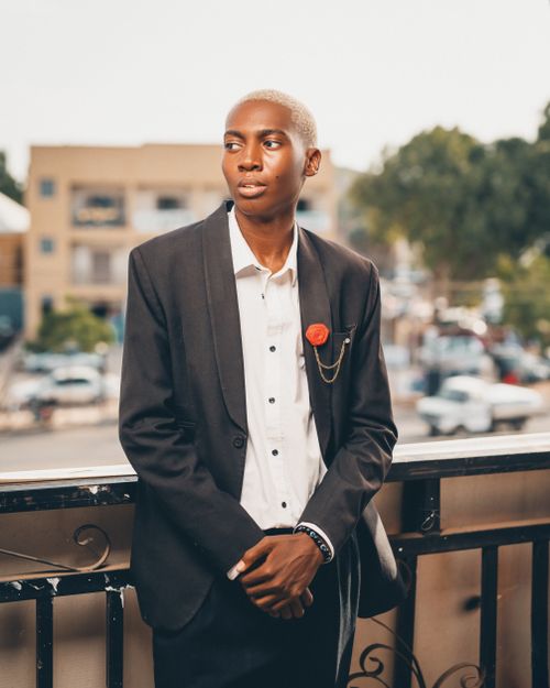 Free Confident young adult in formal attire posing outdoors on a balcony in Kaduna, Nigeria. Stock Photo