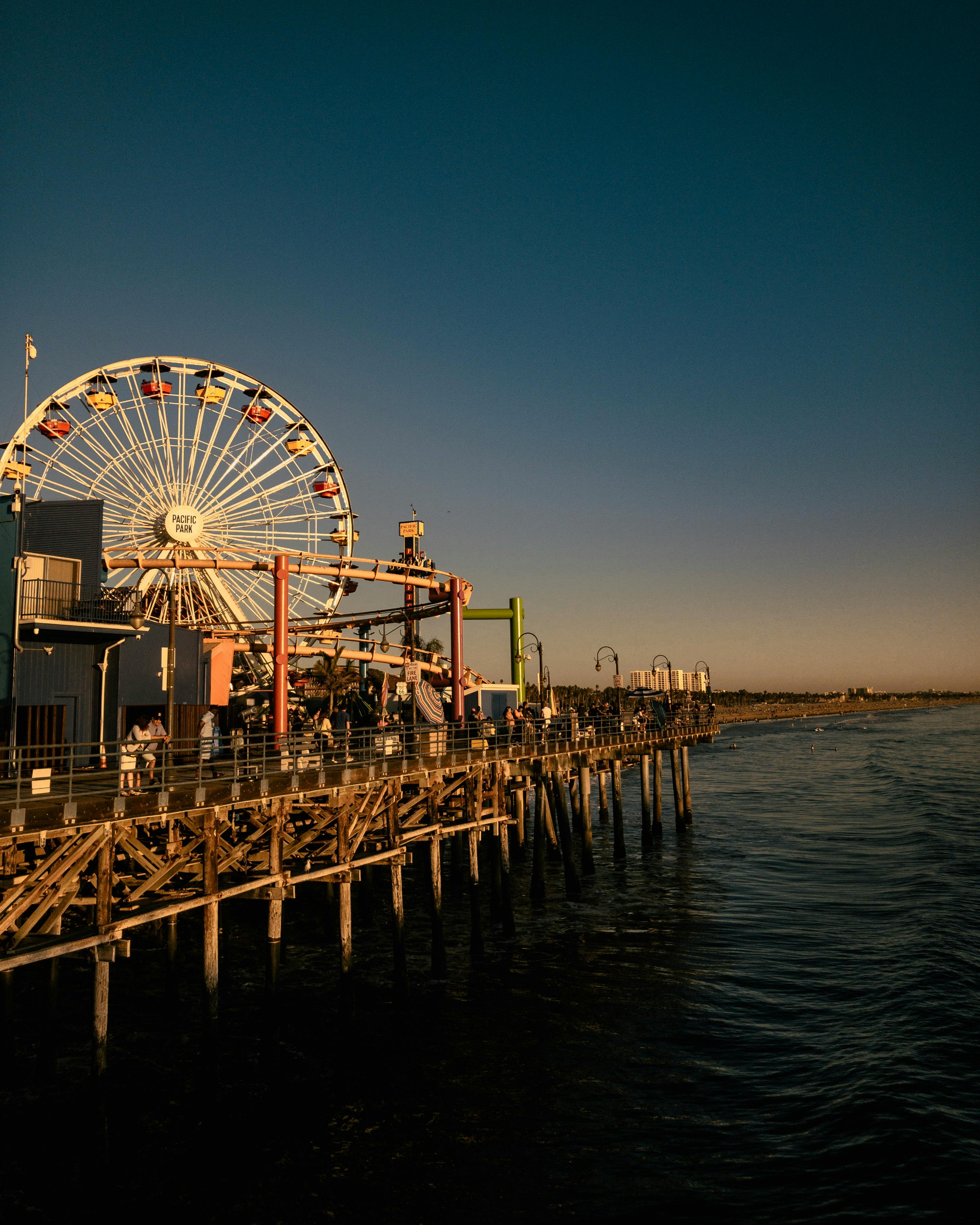 在宁静的海洋背景下，圣莫尼卡码头迷人的日落映衬着标志性的摩天轮